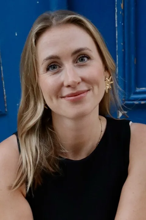 Isabel Jeworski in front of a blue door, smiling